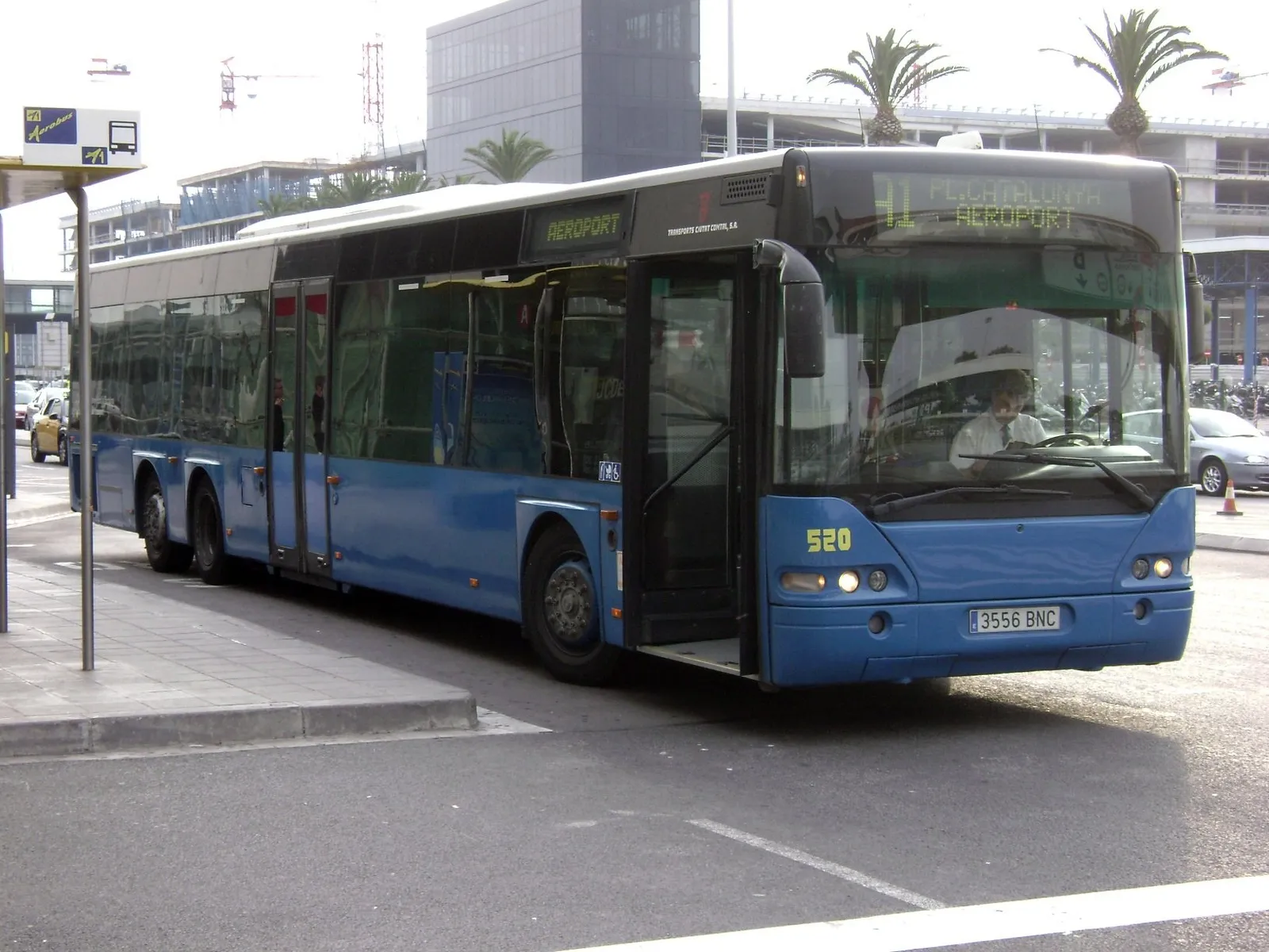 An Aerobus airport express coach outside a Barcelona airport terminal in daylight