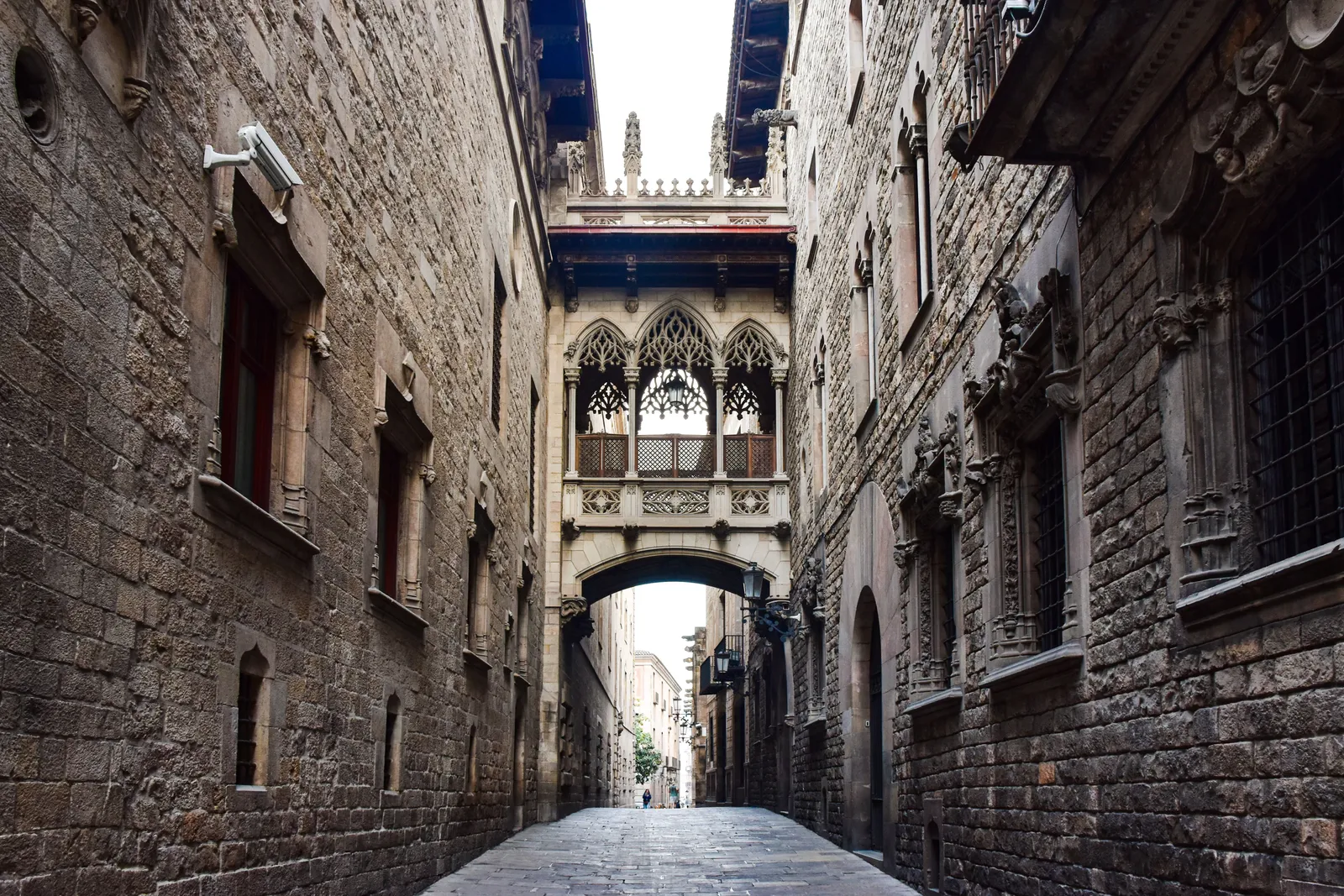 Narrow medieval stone streets of the Gothic Quarter in Barcelona in morning light with shuttered shopfronts