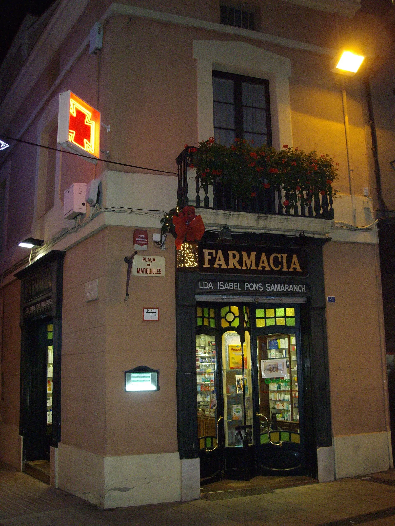 The green cross sign of a pharmacy on a Barcelona street