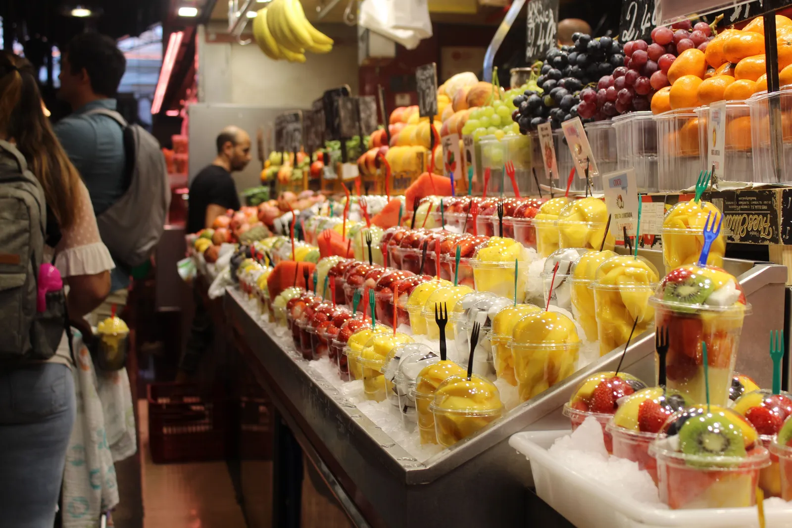 The stalls of La Boqueria market piled with fruit and jamón
