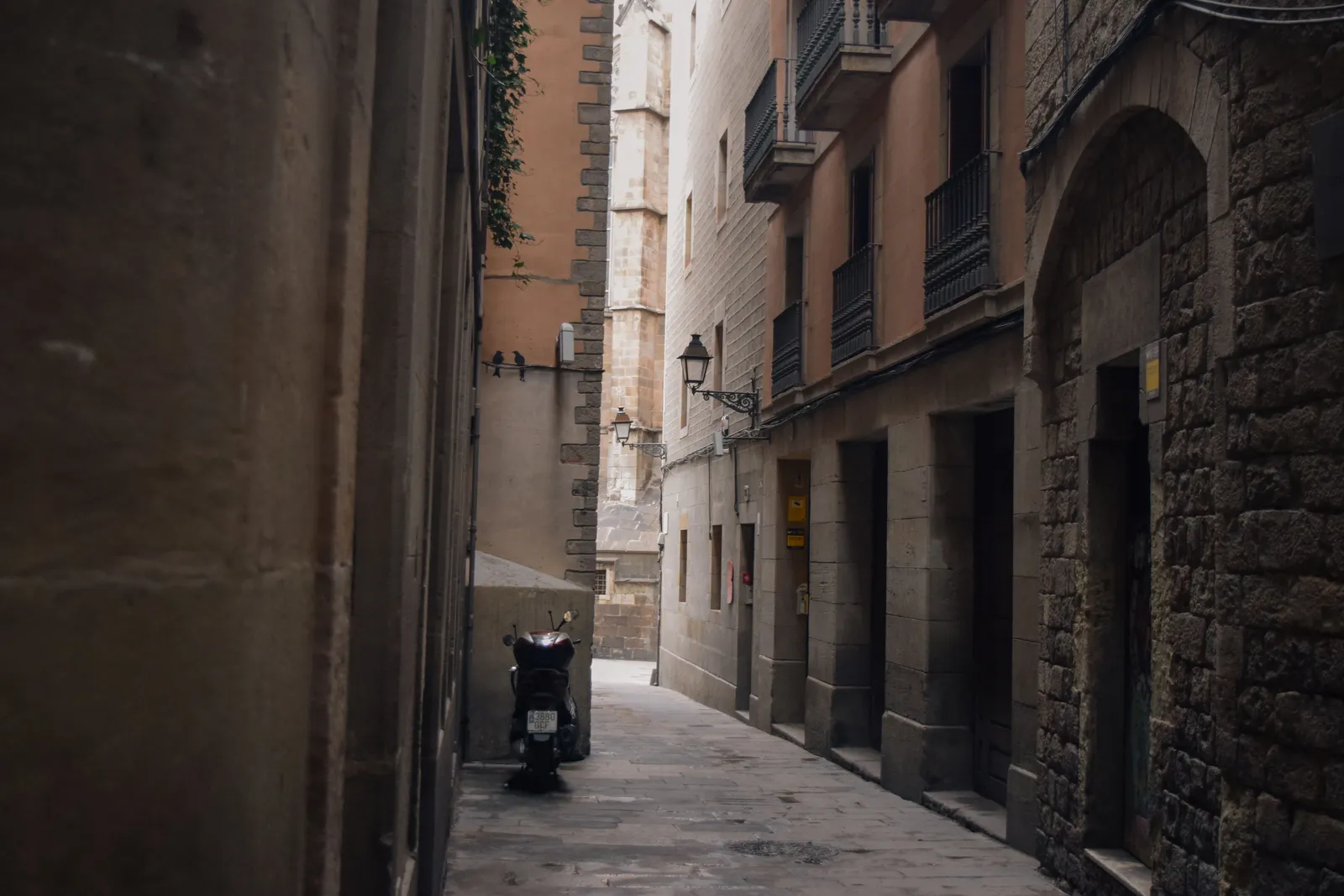 A narrow street in the Gothic Quarter of Barcelona with balconies and shutters