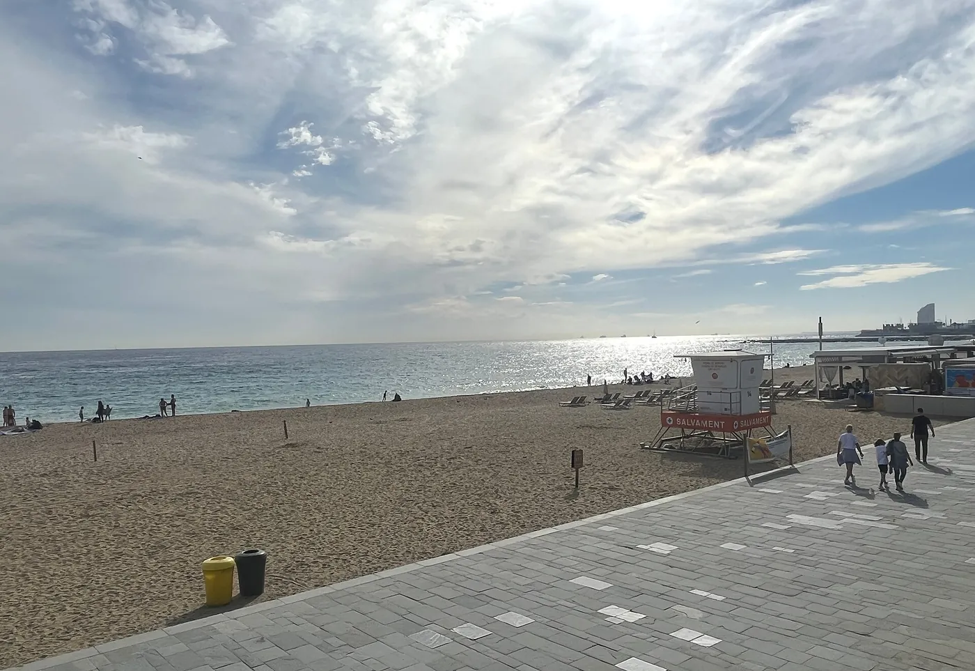 The wide sand and promenade of Bogatell beach in Barcelona, Spain, in daylight