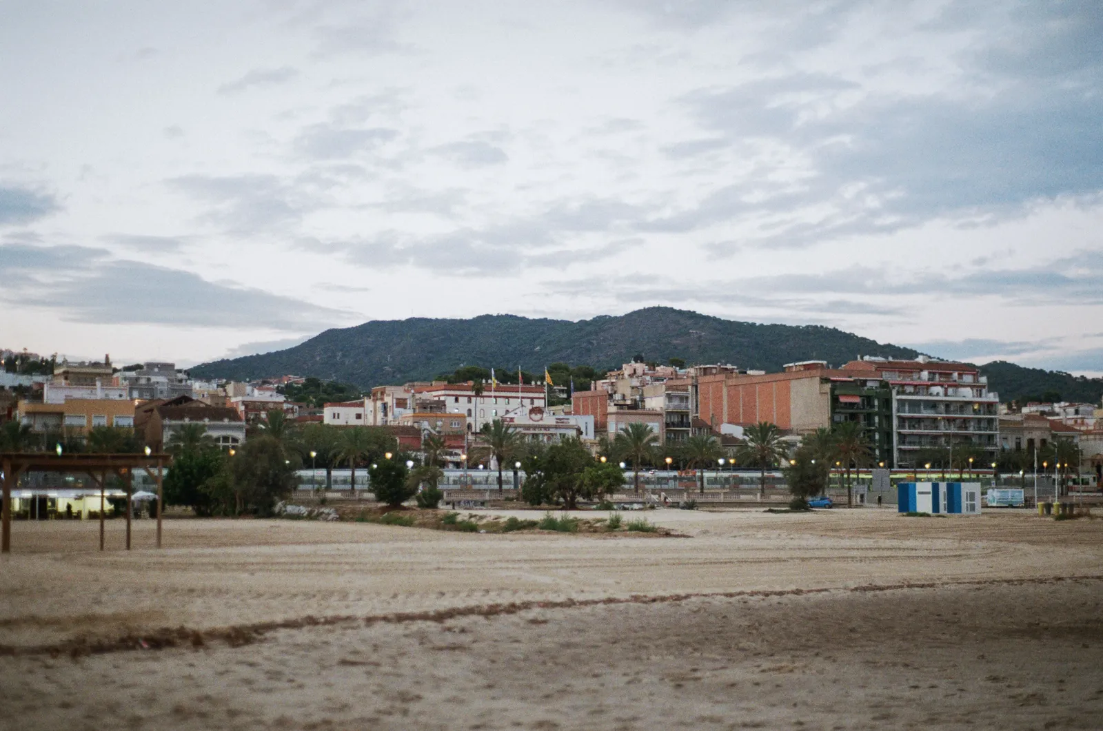 A quiet wide beach north of Barcelona used by local residents, with the coastal railway behind, Spain
