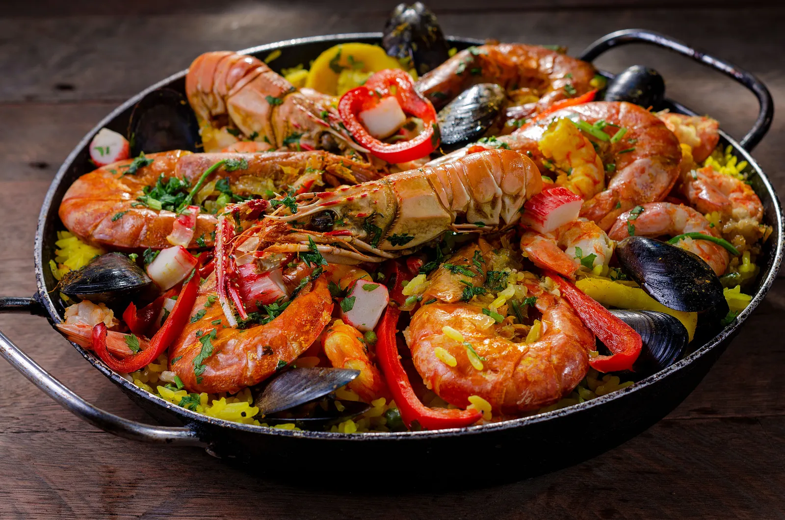 A wide shallow pan of seafood rice cooked to order on a restaurant table in Barcelona, Spain