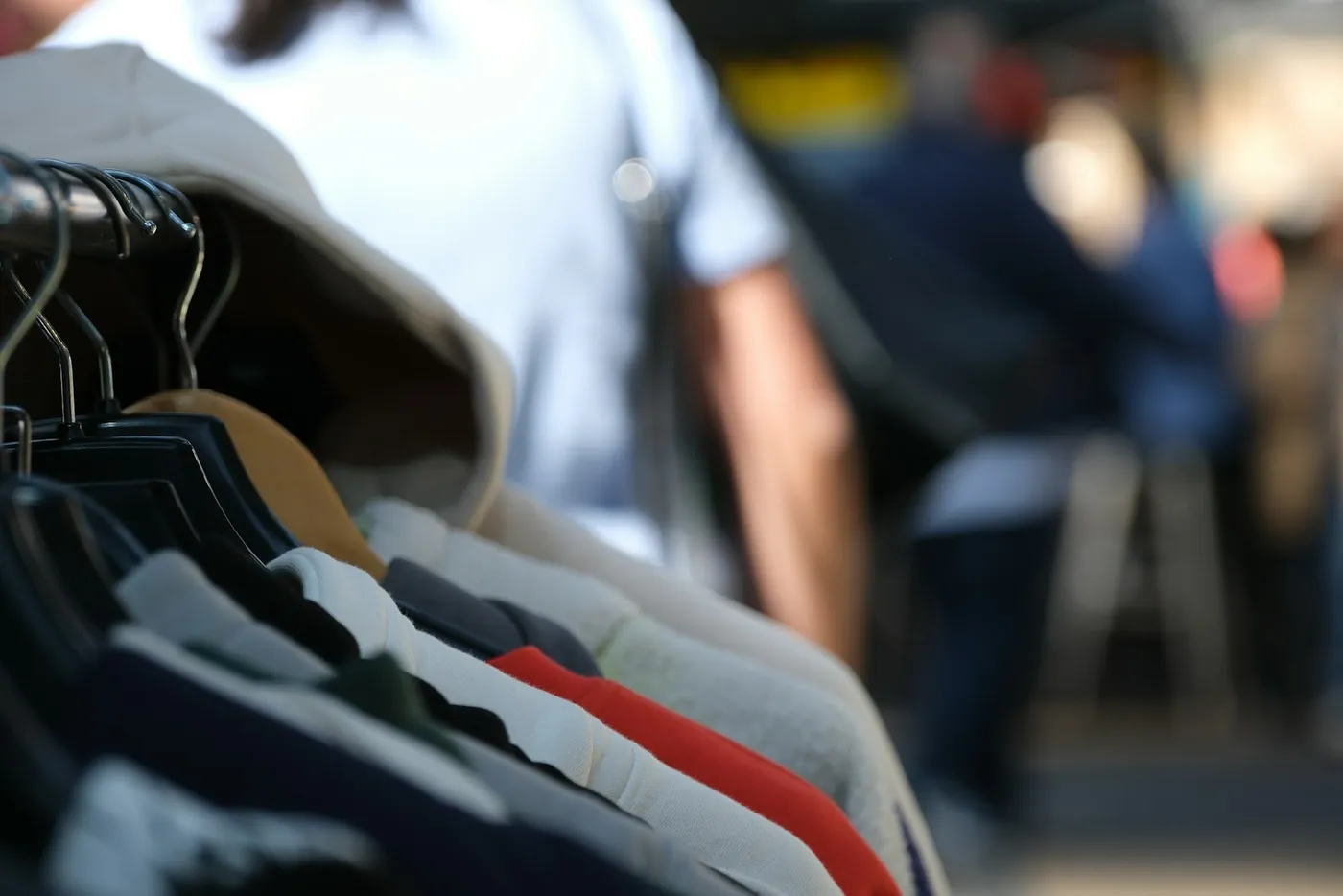 A rail of clothes on hangers at an outdoor market stall