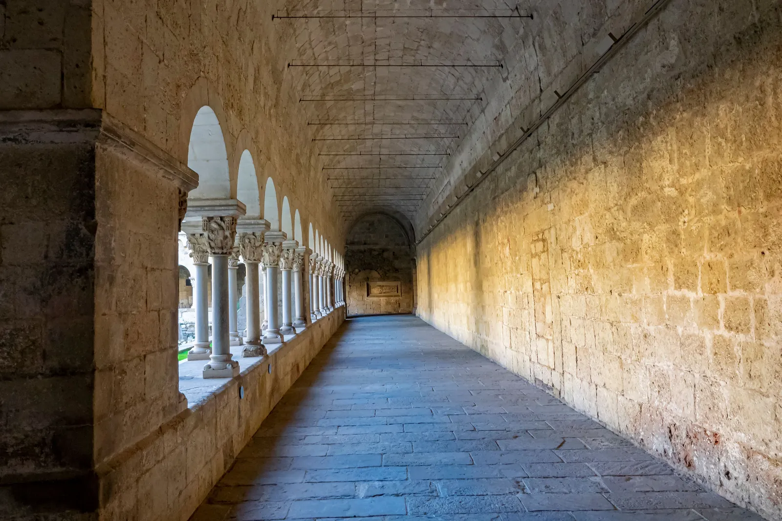 An empty stone corridor in a historic building in Barcelona, Spain