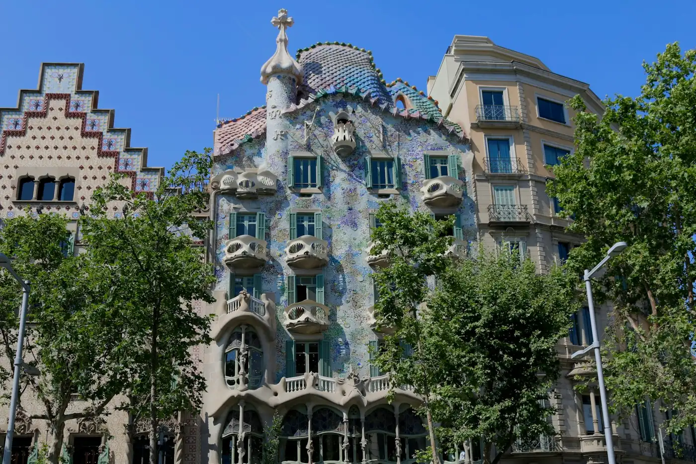 An ornate corner building with a clock on a boulevard in central Barcelona, Spain