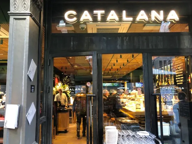 A lit glass front with an illuminated sign, and a counter of glasses and plates inside