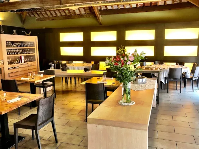 A hall with wooden ceiling beams, yellow light niches and a bouquet on a counter