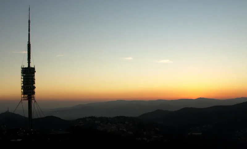 Tall communications tower on a mountain ridge at sunset