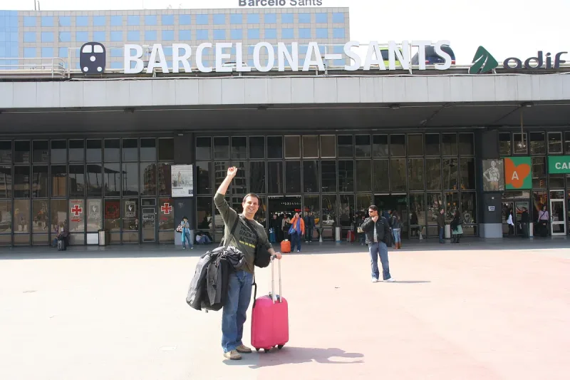 Railway station frontage lettered Barcelona Sants with travellers outside