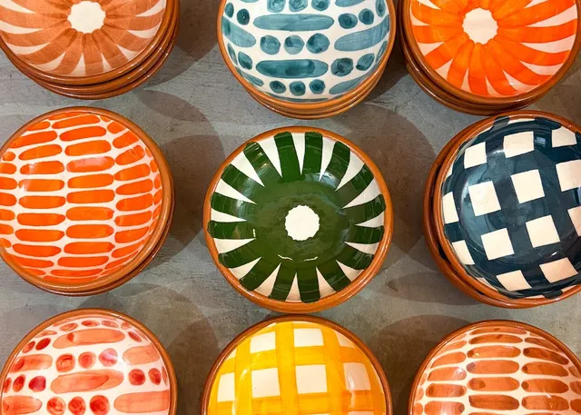 Hand painted ceramic bowls in orange, green, yellow and dark blue