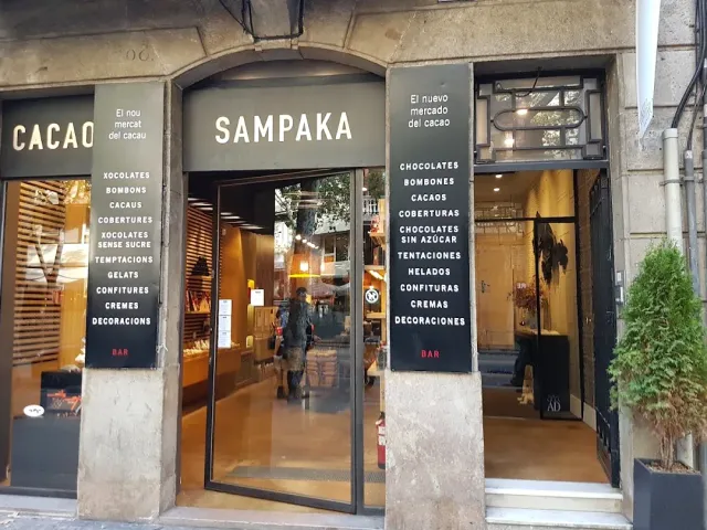 A dark shopfront with two white product lists and an open glass door