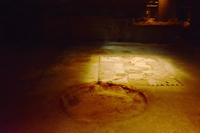 Stone floor of a Roman laundry lit in an underground excavation